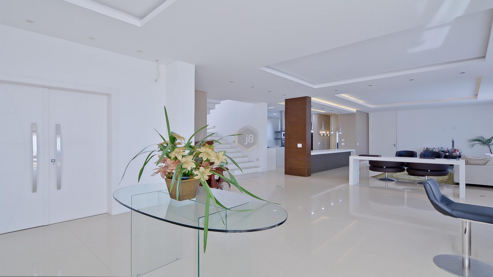 Amplo hall de entrada clean com mesa de vidro e arranjo de flores
