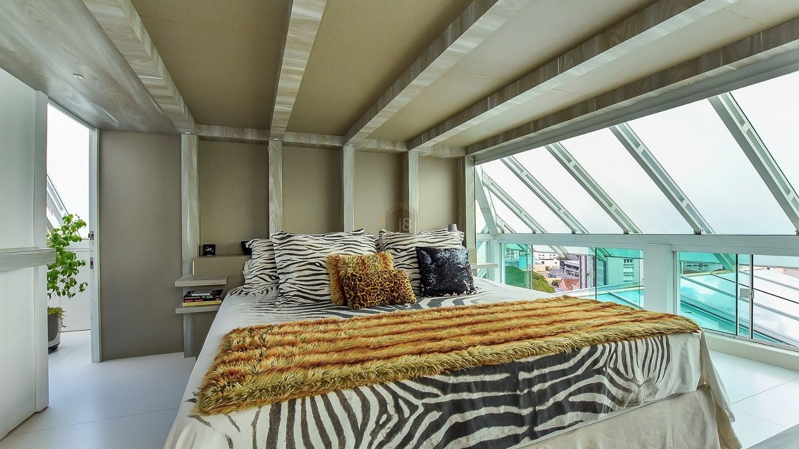 quarto em ático com colcha estampada e decoração extravagante
